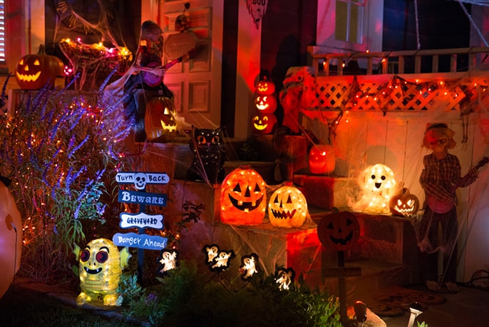 A neighborhood home is decorated with Halloween lights and pumpkins