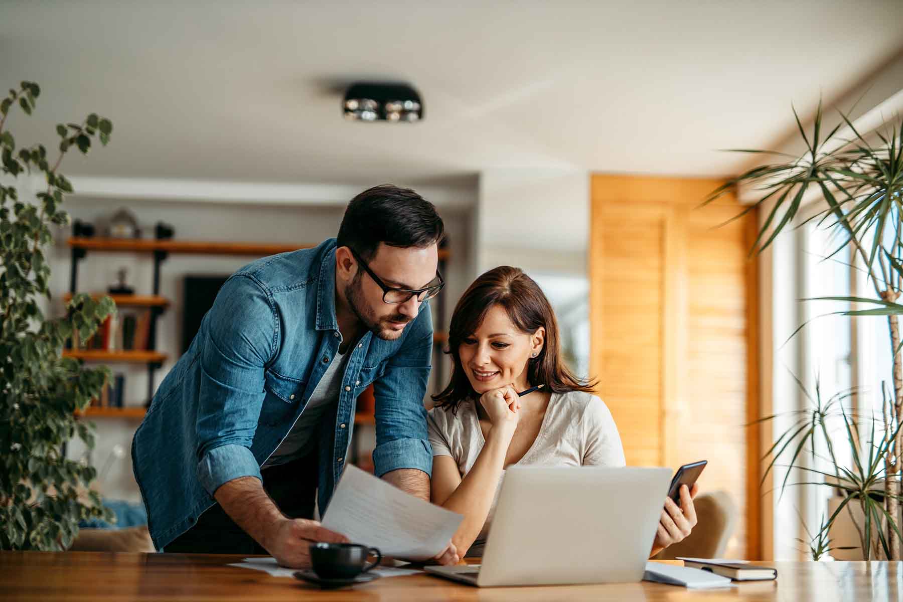 A man and woman review finances in their kitchen