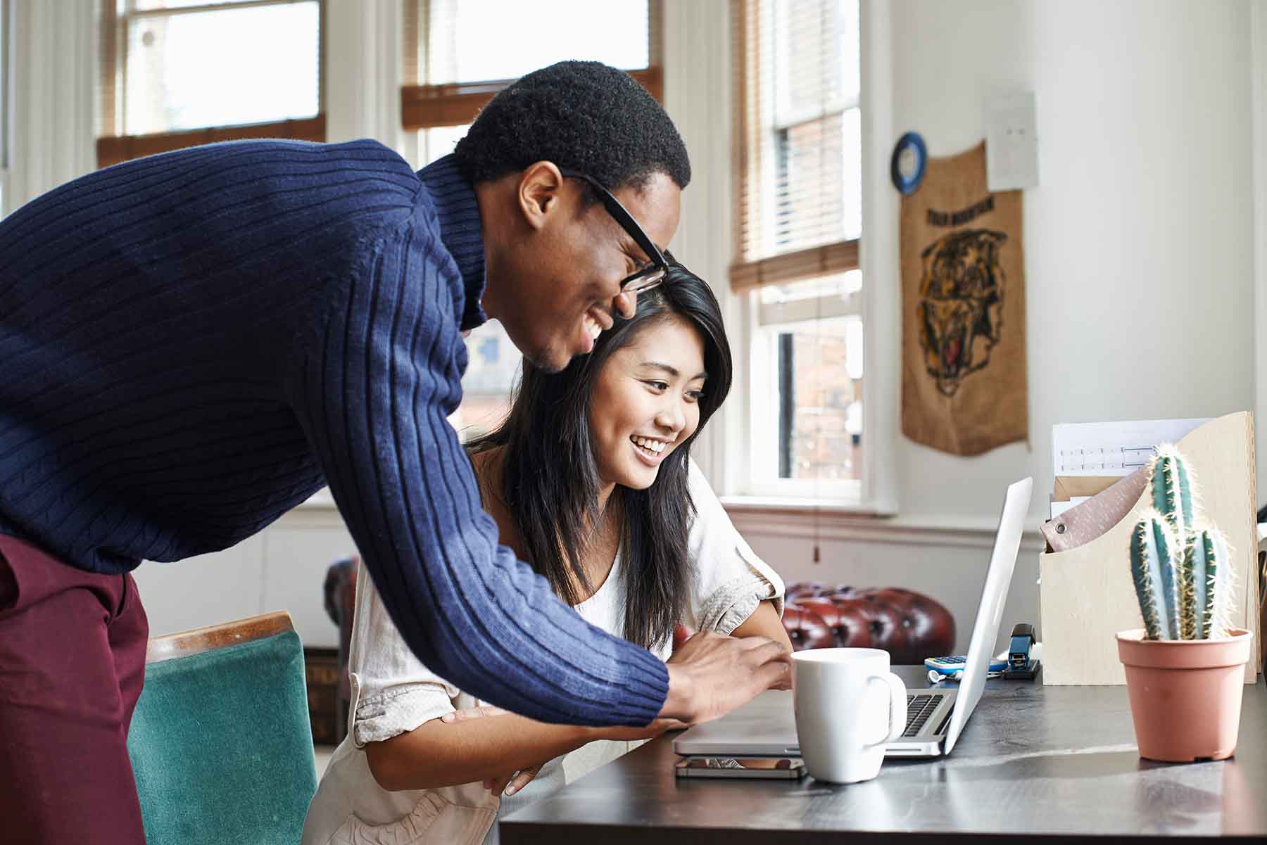 A young couple looks at finances on a laptop