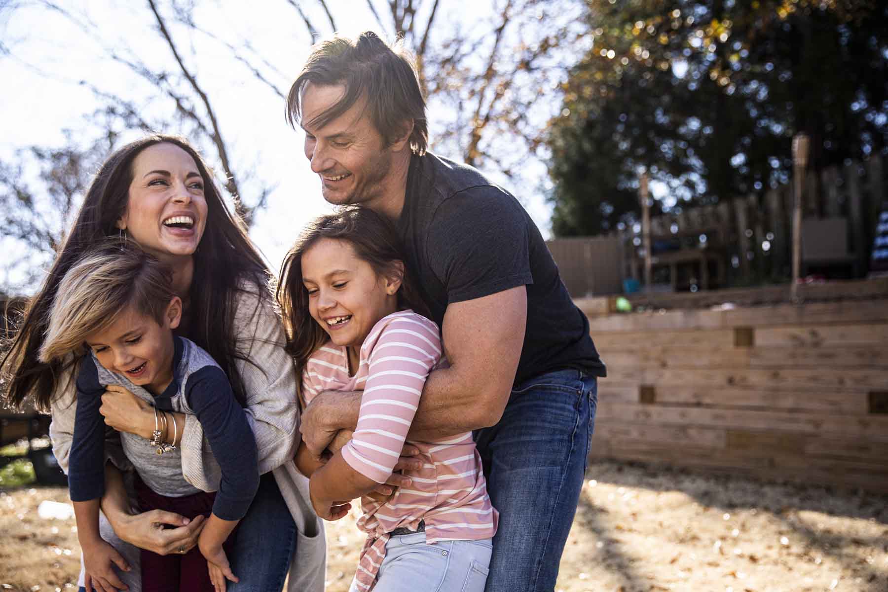 A family playing with their children in their back yard