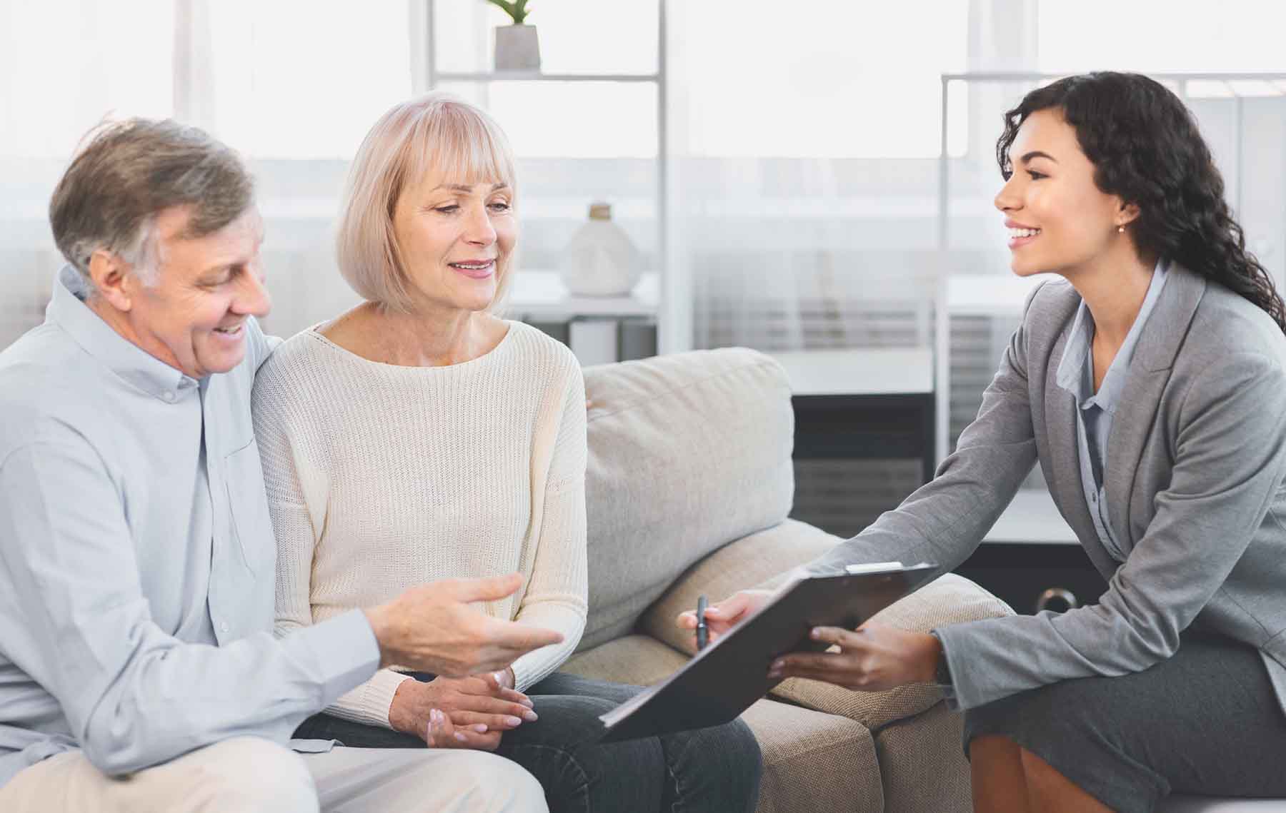 Senior couple signing paperwork with agent