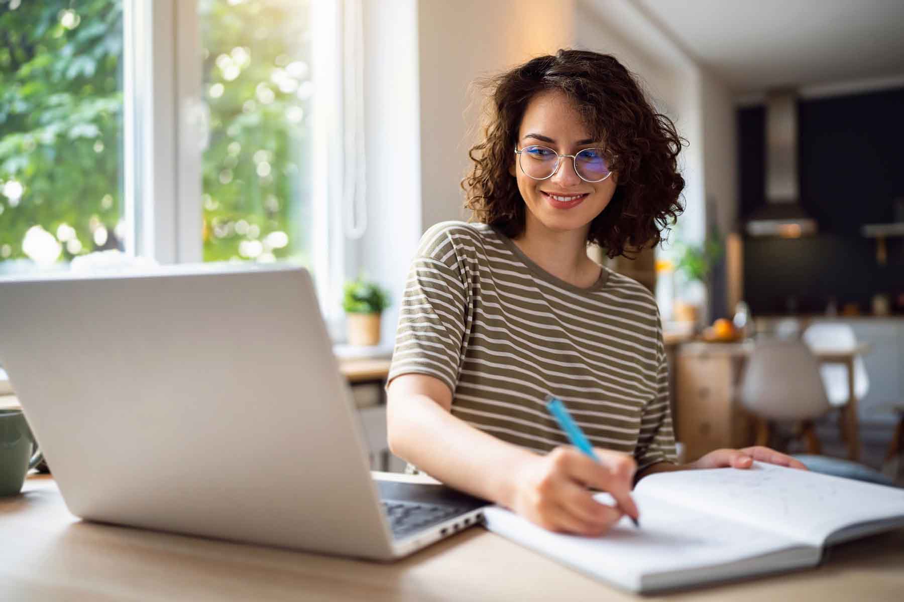 Woman working on her budget sitting in front of a laptop