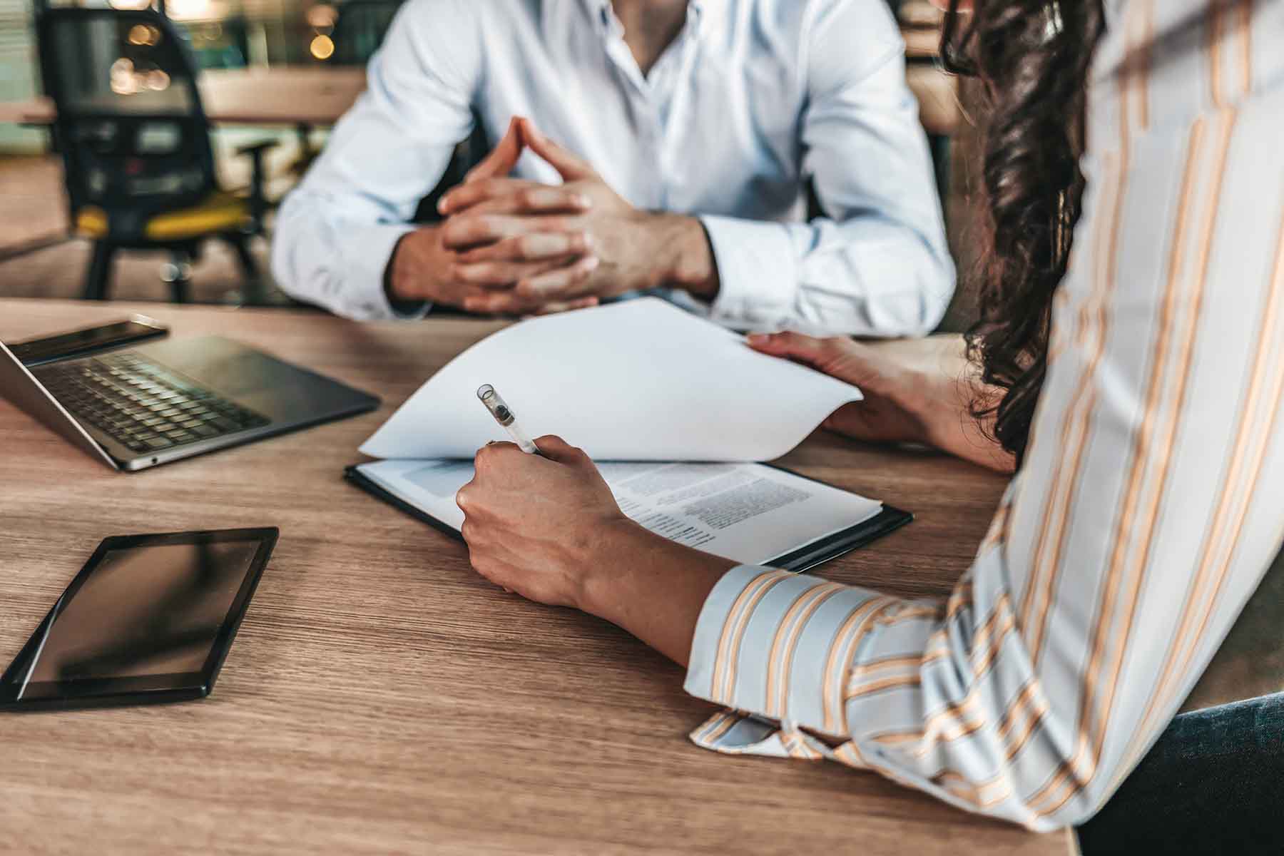 Man and woman filling out divorce paperwork at a desk.