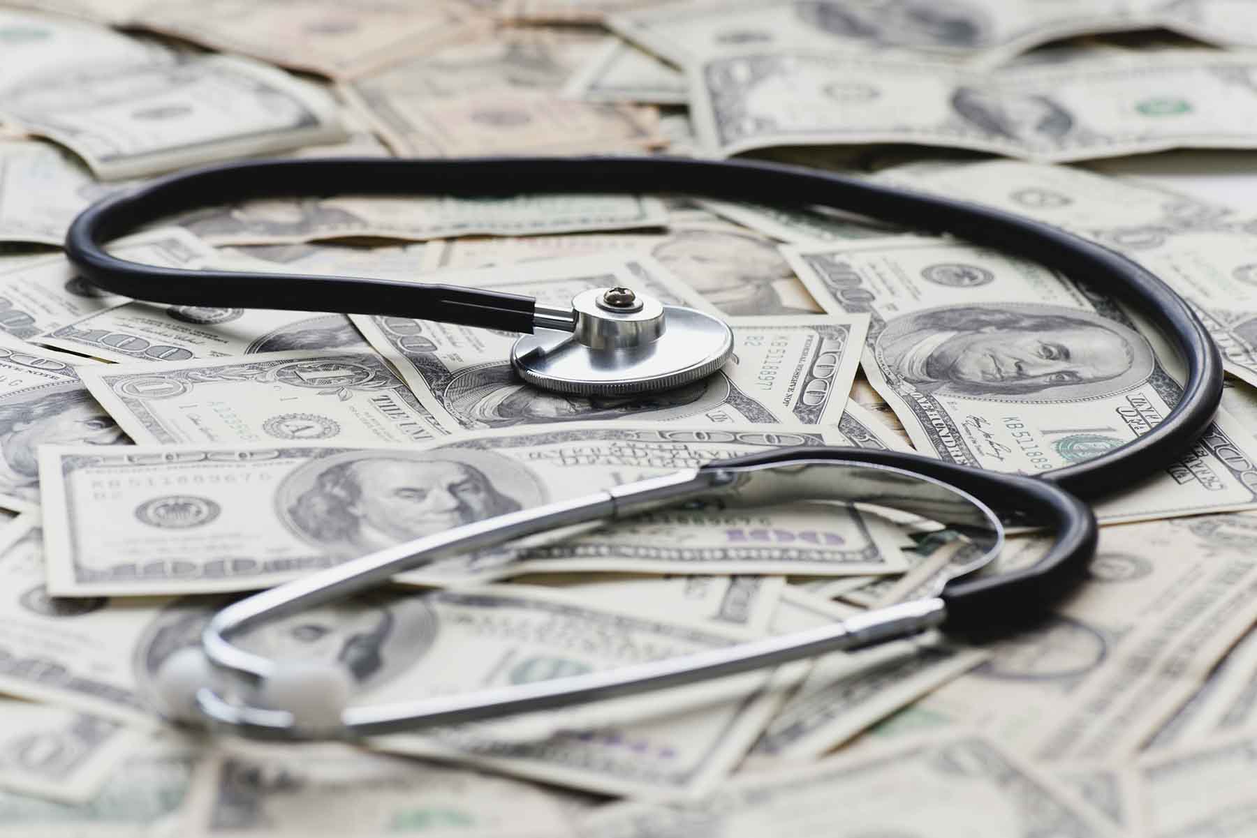 Stethoscope on a pile of US bills