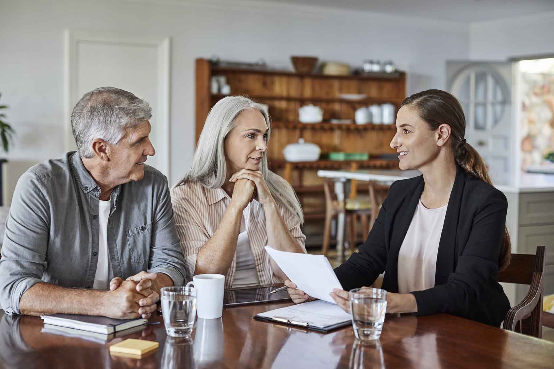 Mature couple meeting with a financial advisor in their home