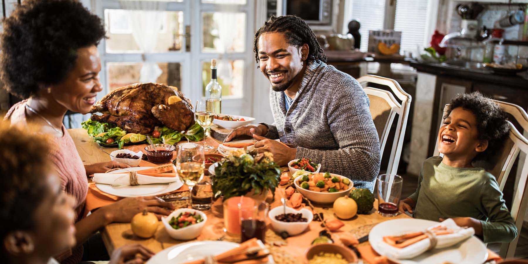 A young family sitting around their dining room table for Thanksgiving dinner