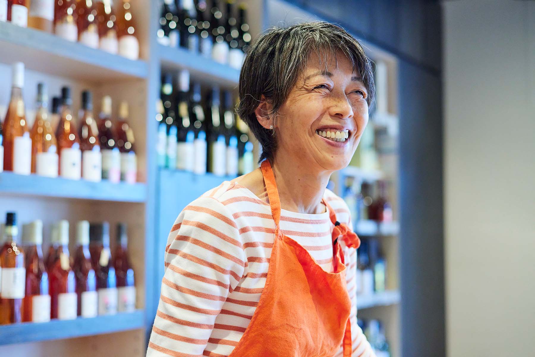 A woman standing behind the counter in her small business