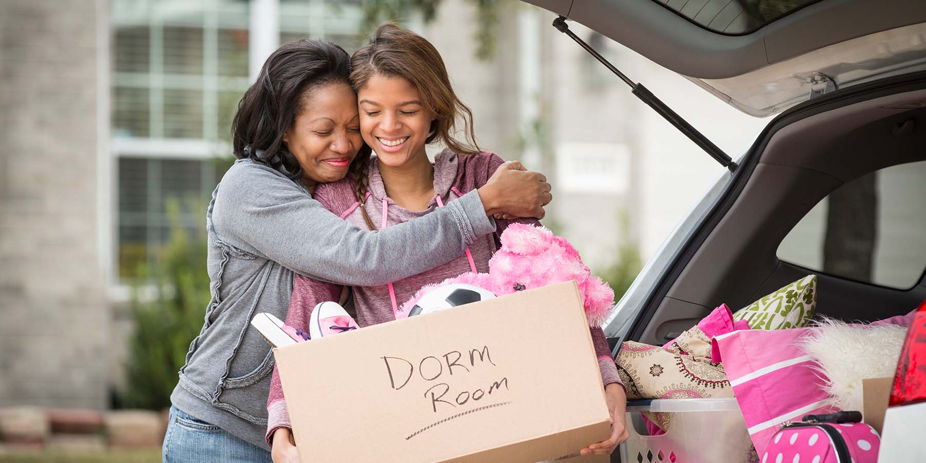 A mother hugging her daughter as she heads off to college