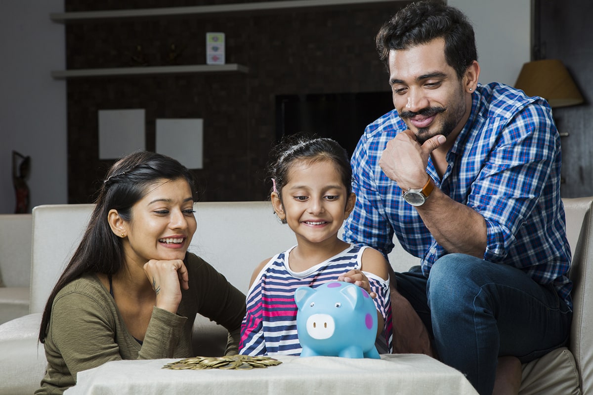 Family putting coins into a piggy bank