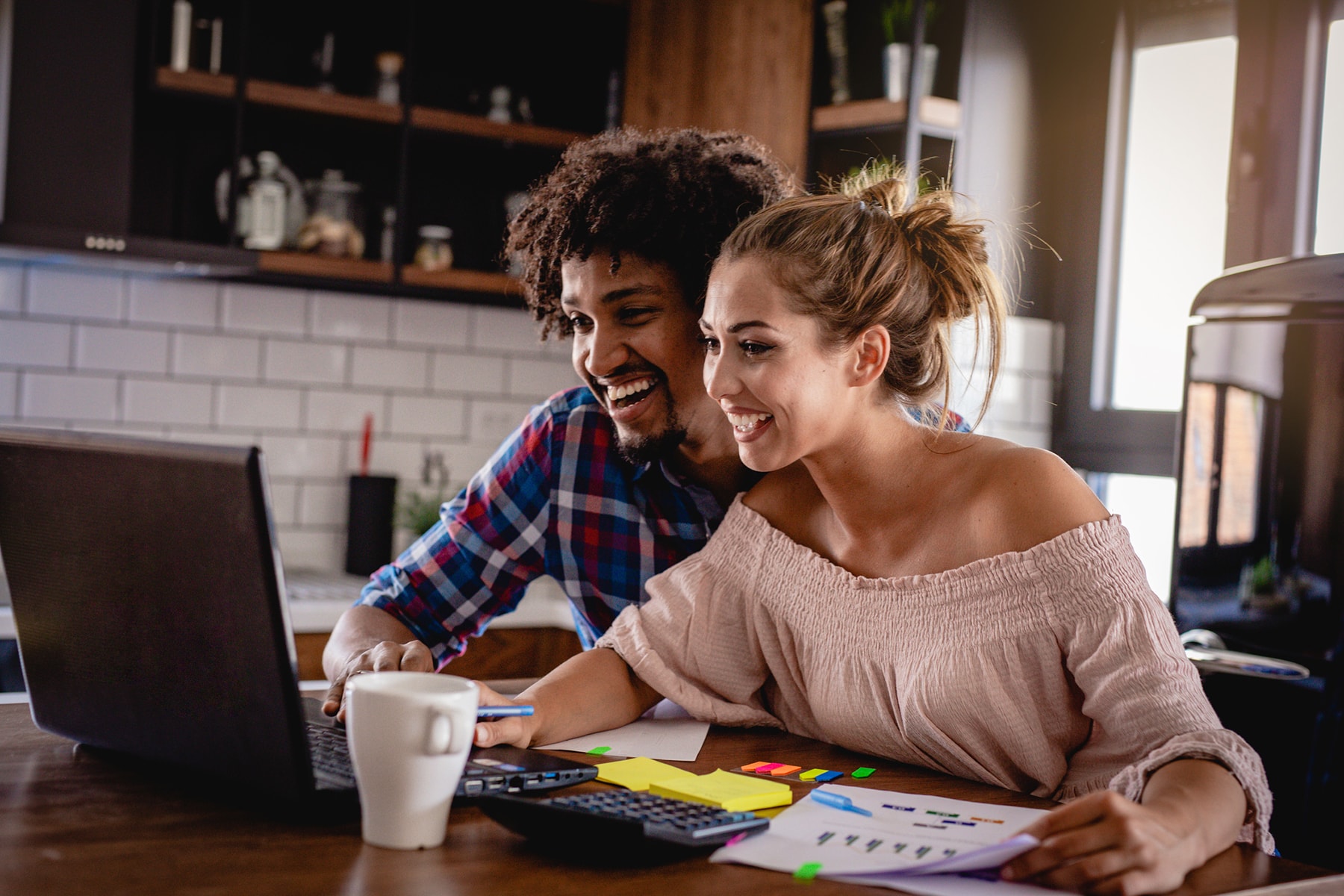 A young couple manages their finances together in the kitchen