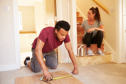 couple painting and measuring house