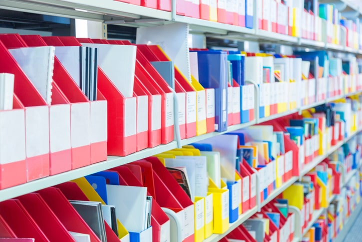 A shelf of folders, binders, and notebooks in a stationery store.