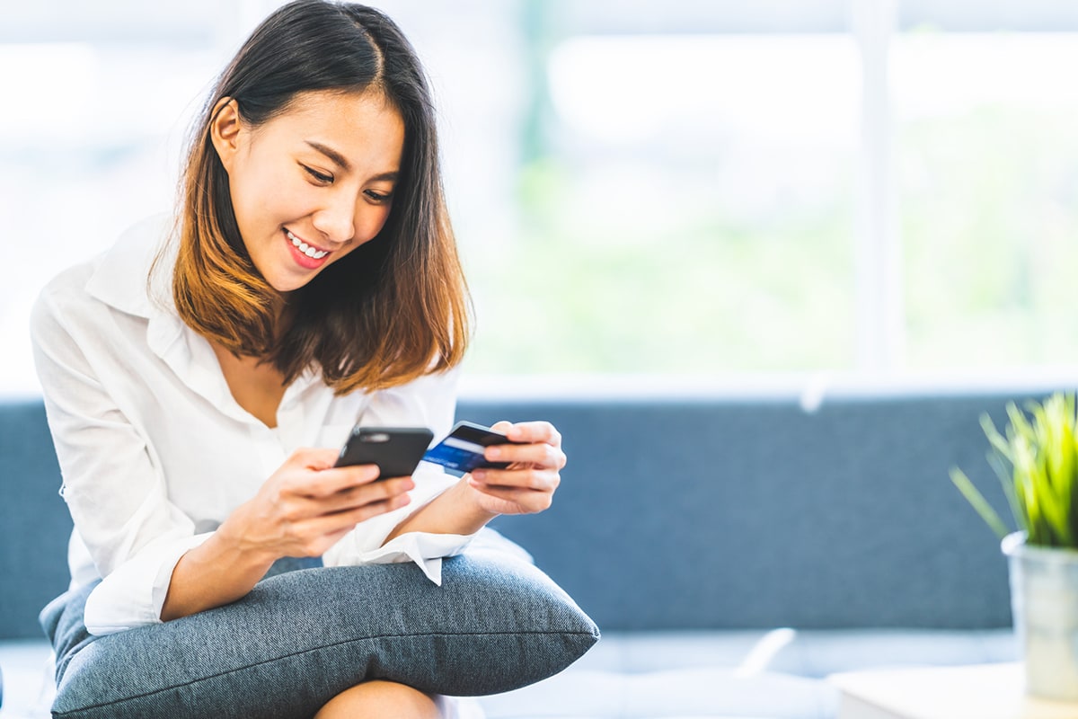 Young woman using a credit card to make a mobile purchase