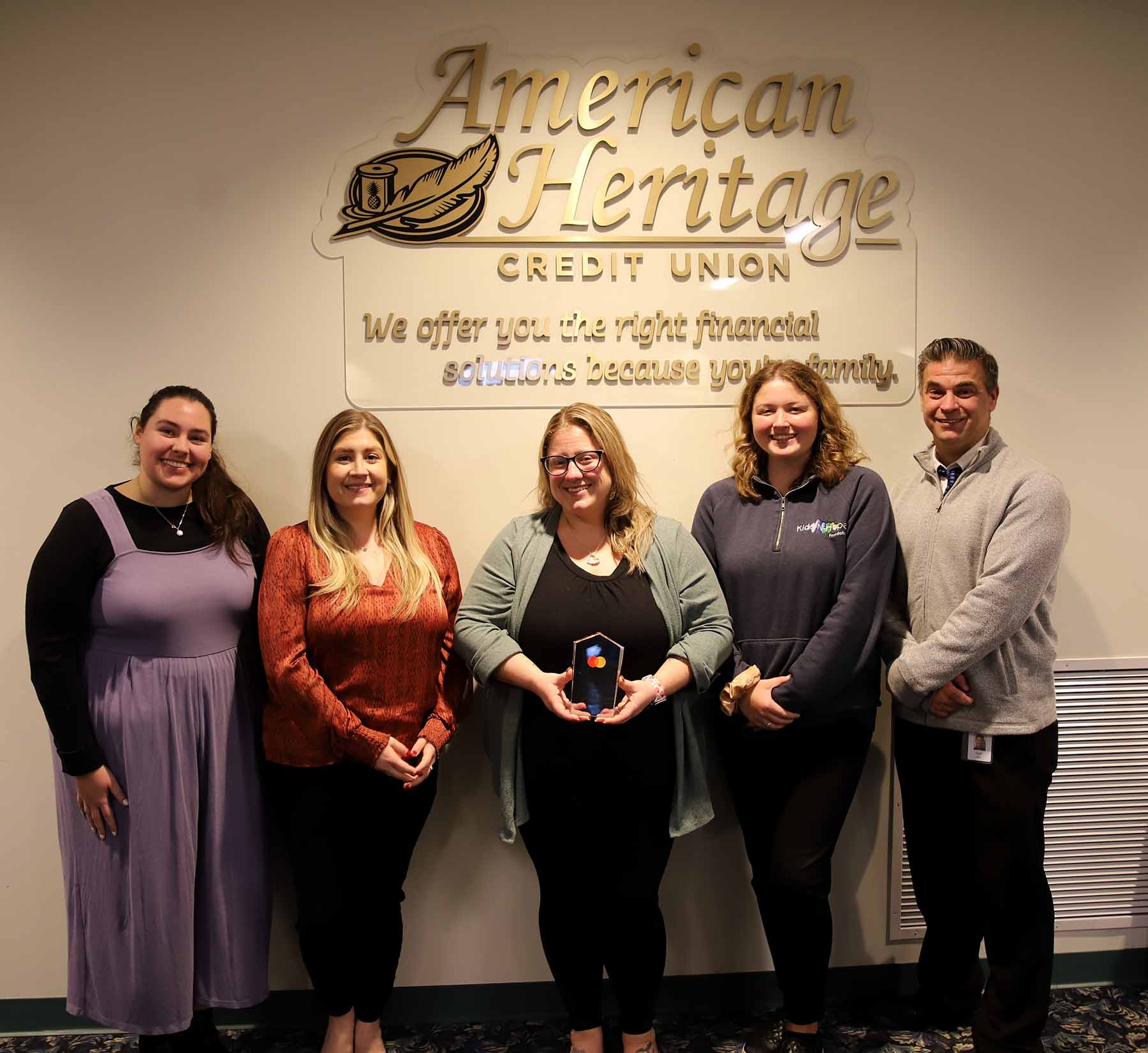 American Heritage associates standing with Mastercard's 2025 "Doing Well by Doing Good" Award