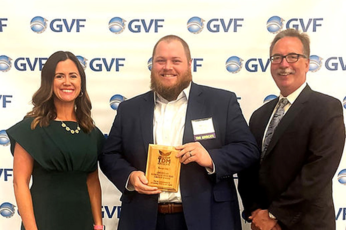 American Heritage Associate (center) presented with TDM award by Representatives (left and right) of GVF.