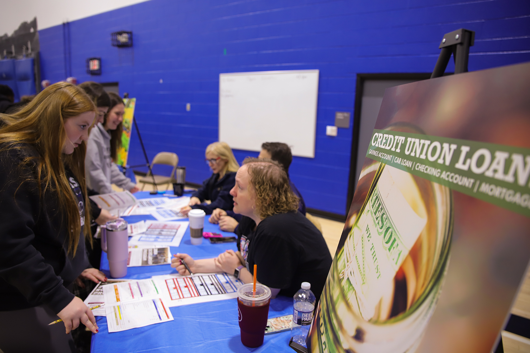 Students meet with volunteers to discuss credit union loans during MaST Community Charter School's Reality Fair.