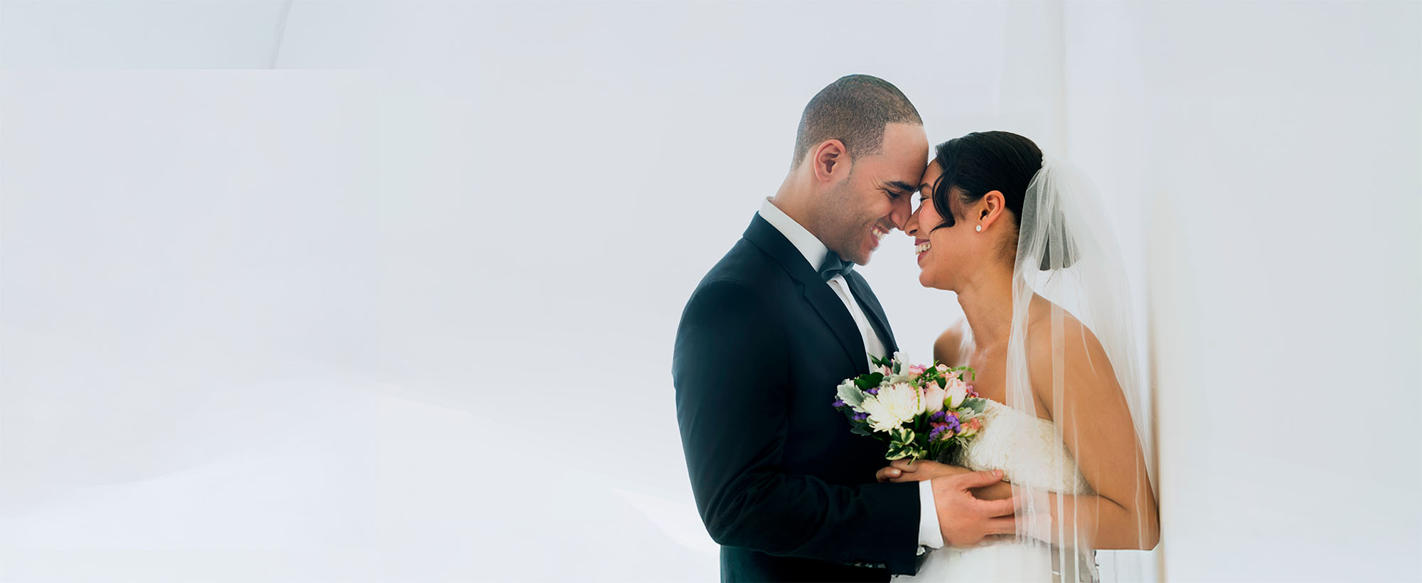 a newlywed couple on a white backdrop