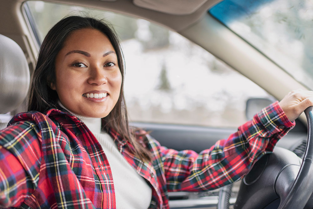 woman sitting in her car in a flannel